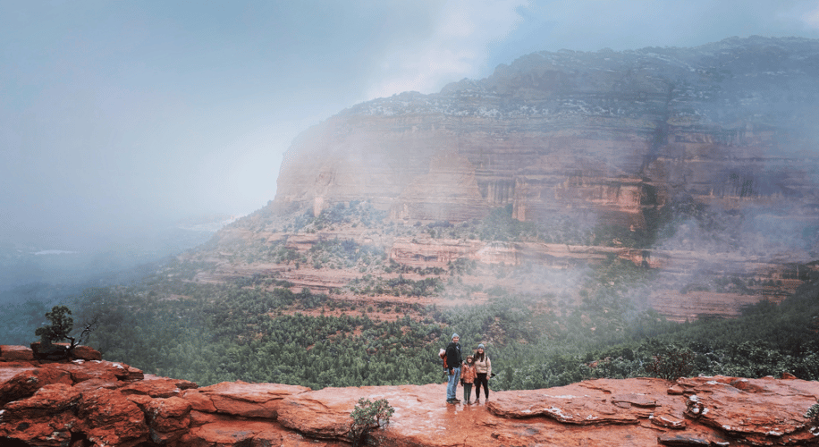 Family standing on a mountain in the mist