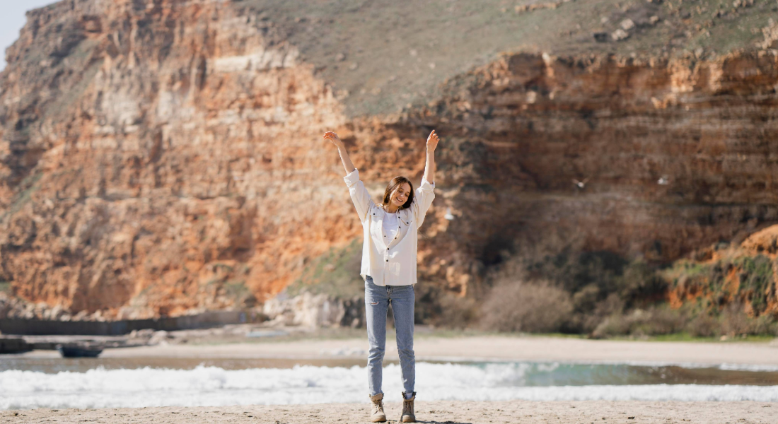 woman with her arms up in the mountains